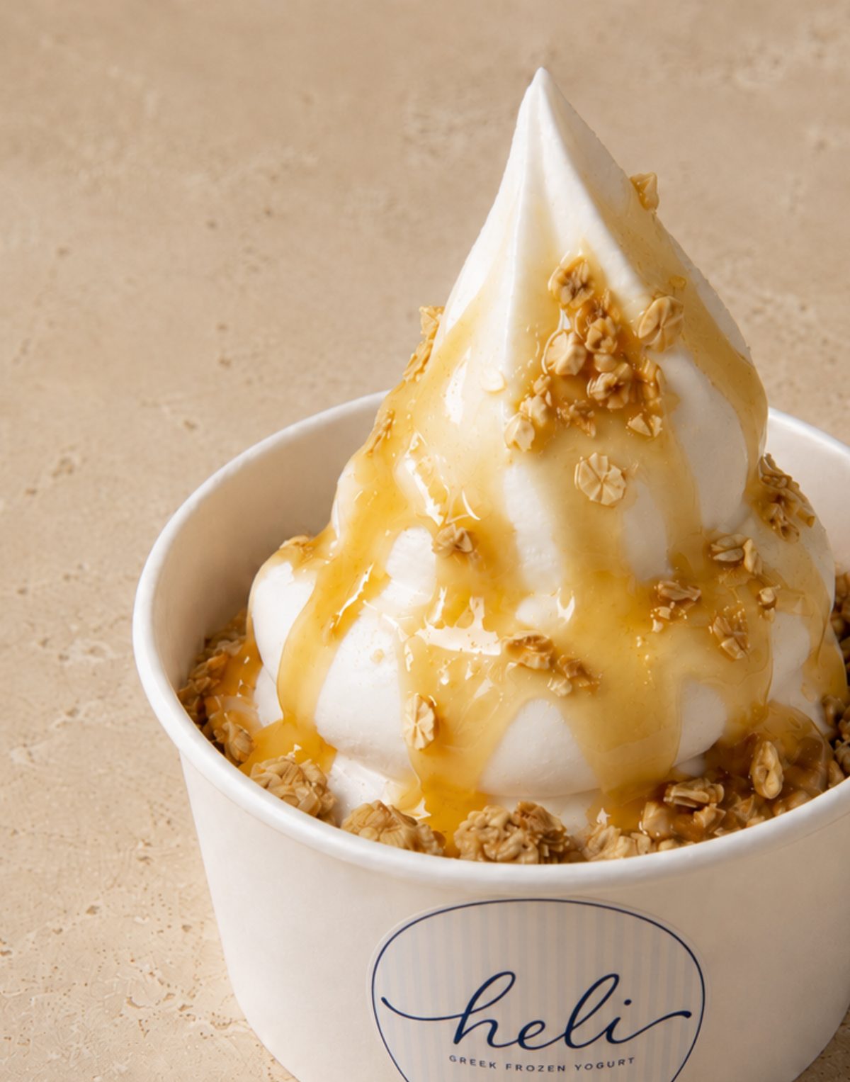 Close-up of a Heli premium Greek frozen yogurt swirl with honey drizzle and granola
